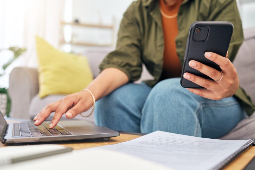 persona mirando el celular con una libreta al lado